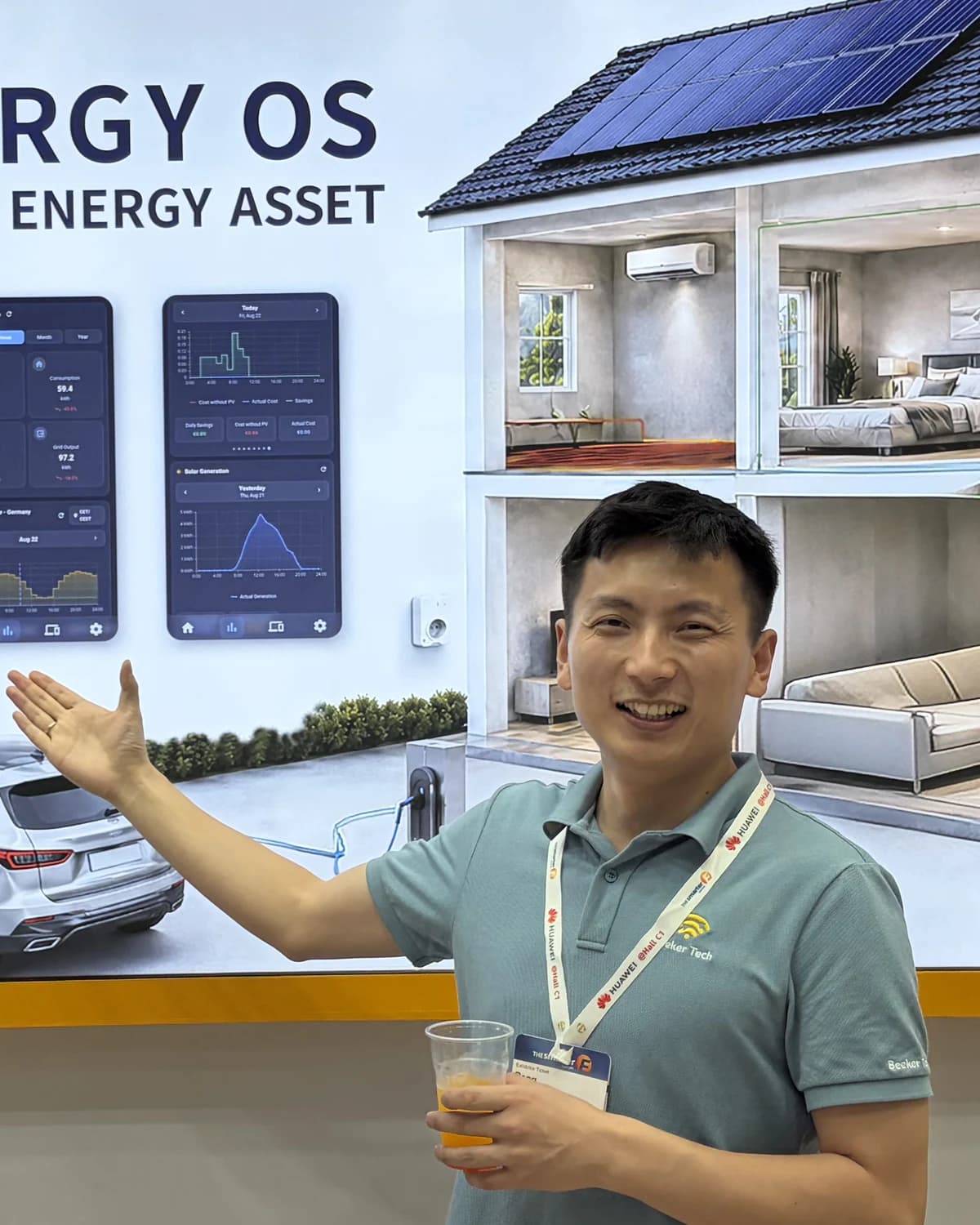 Peng Yang on the OptiBee stand at an energy trade fair, in front of a cutaway house showing photovoltaics, storage and EV charging.